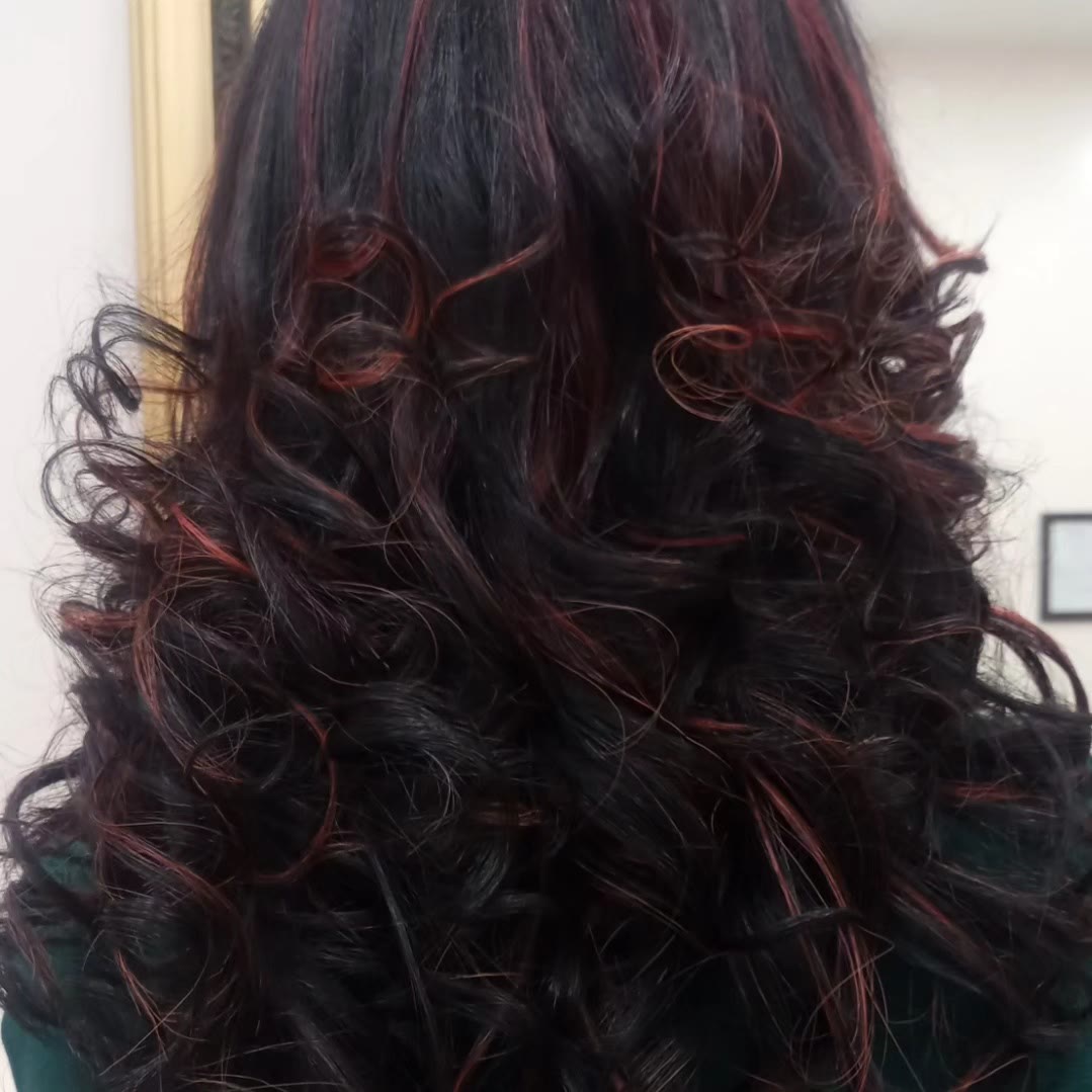 Black curly hair with bright red highlights running through it