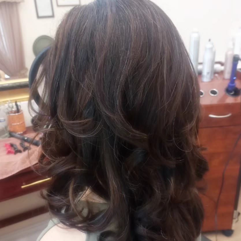 Dark brunette layered cut blow-dried into loose curls