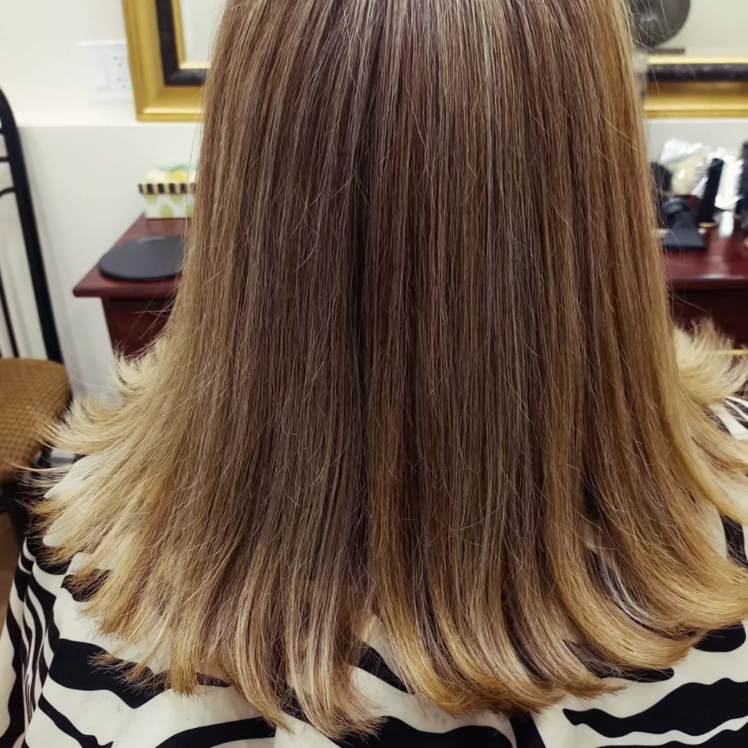 Caramel and blonde highlights on a mid-length cut with flicked ends