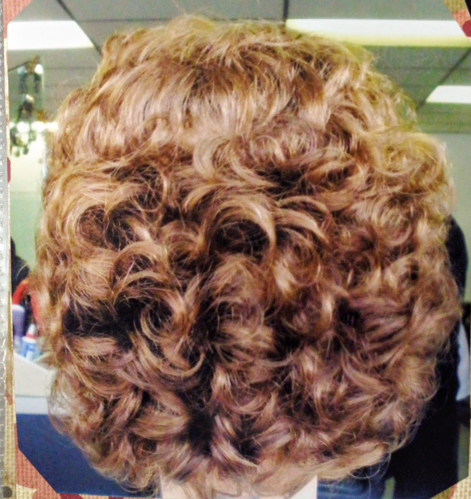 Blonde hair set into tight, full curls